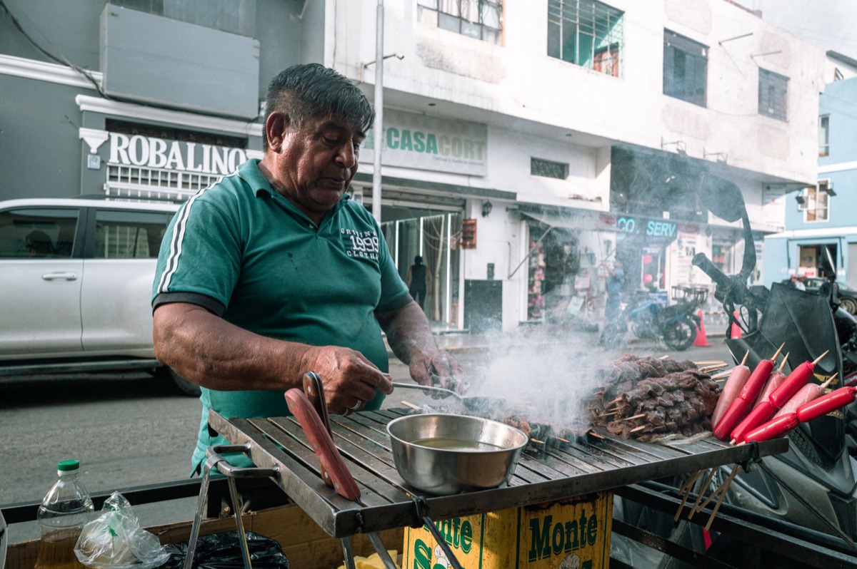 Latin American food vendor in Miami market with colorful ingredients and cooking tools