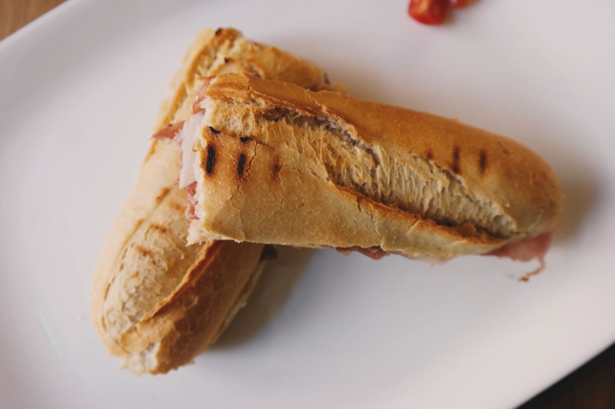 Close-up view of a Cuban sandwich with layers of bread, pork, and avocado