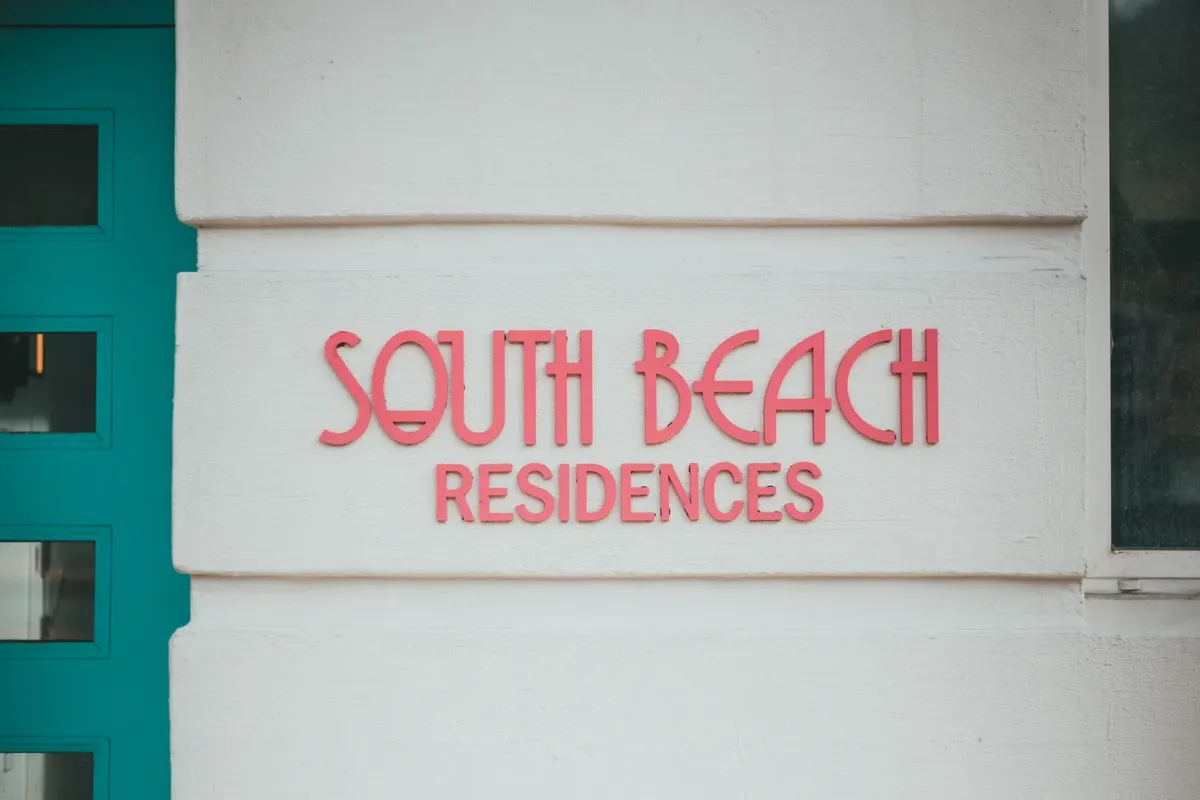 South Beach Residences 입구 표지가 외부 벽에 있는 초점 이미지.